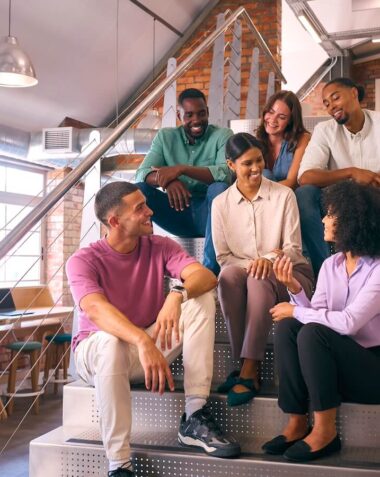 smiling multi cultural business team sitting on stairs